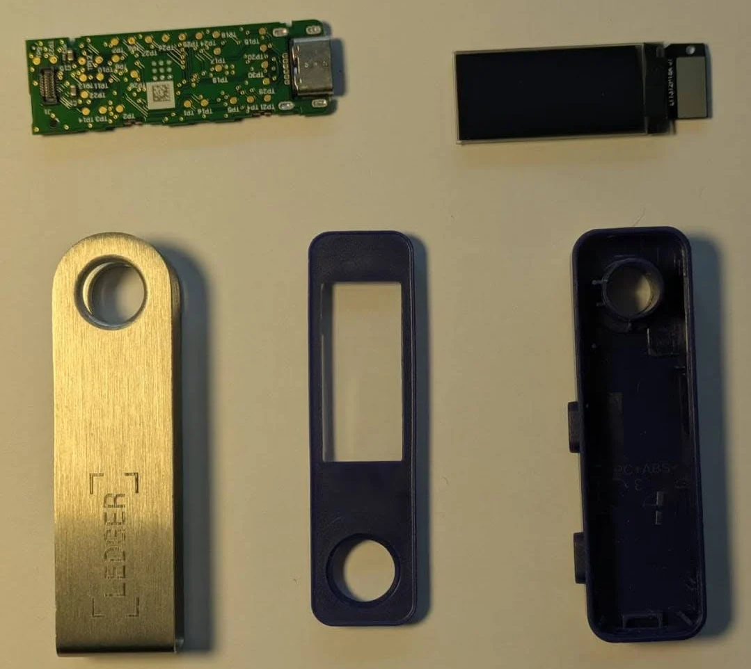 Ledger Nano S Plus desmontada com os componentes internos oficiais: placa de circuito, tela OLED e invólucro